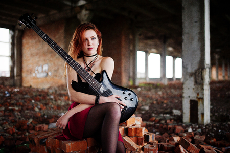 80818258-red-haired-punk-girl-wear-on-black-and-red-skirt-with-bass-guitar-at-abadoned-place-portrait-of-goth.jpg