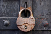 rusty-lock-on-a-metal-medieval-door-picture-id172158751